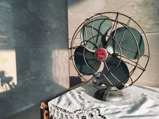 black desk fan on white and black floral table cloth