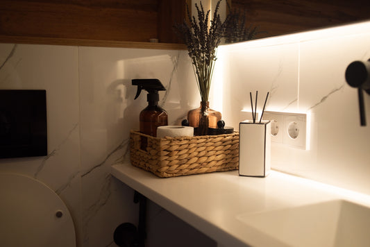 A bathroom with a sink, toilet and a basket on the counter