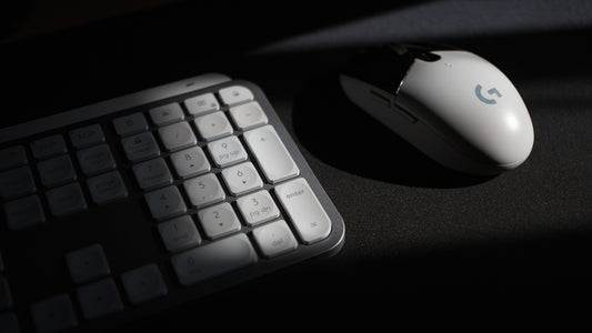 White computer mouse and keyboard in shadow