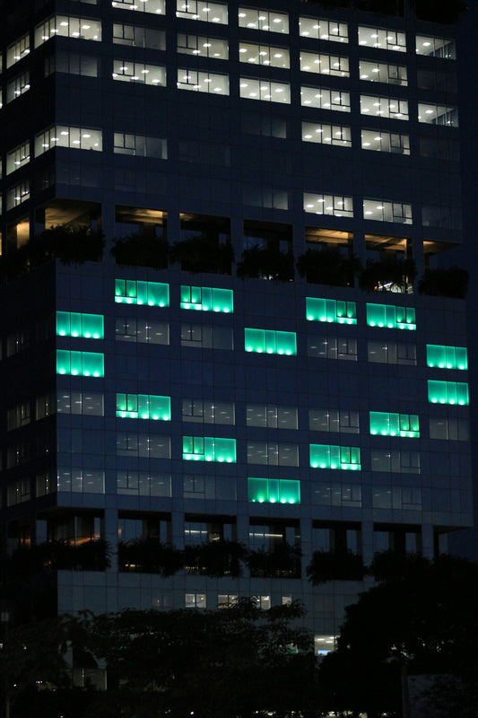 Modern skyscraper illuminated with green lights at night