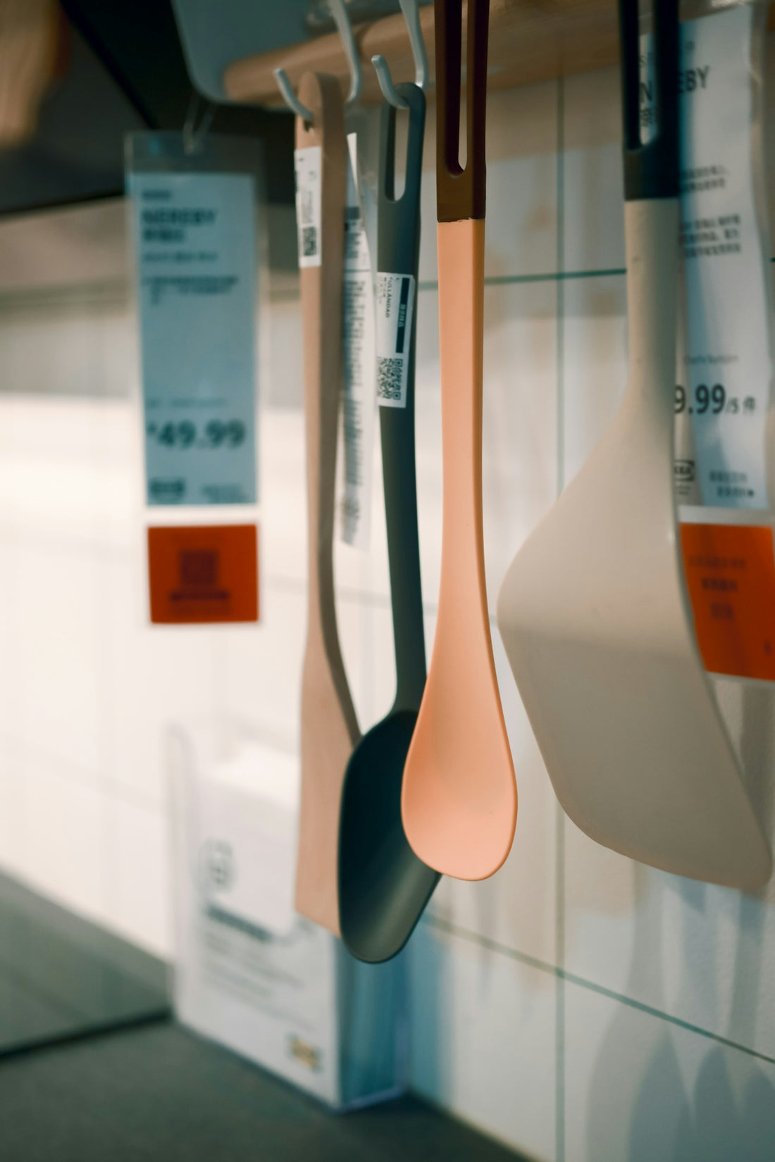 Kitchen utensils hanging on a rack with price tags.